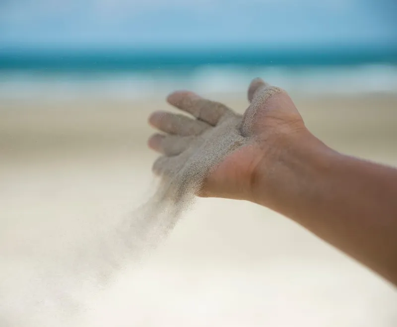 Hand let go of woman release sand on beach